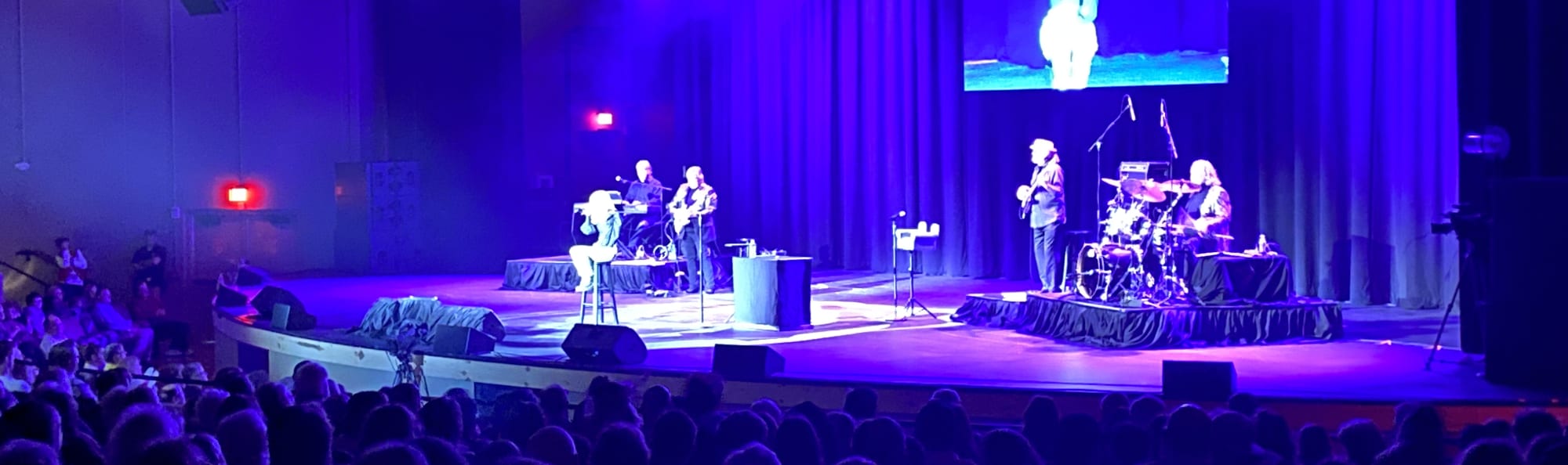 signer on stage in chair washed out by the lights Sarasota